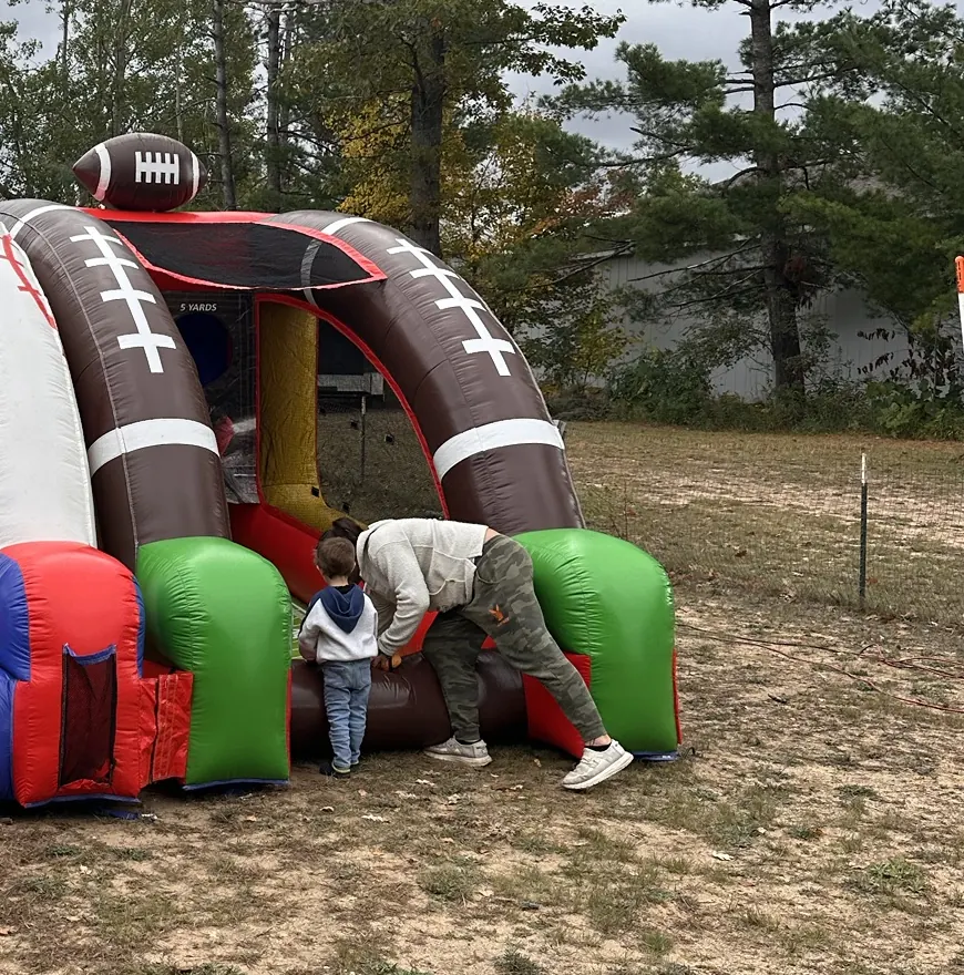 Inflatable games in the fenced field behind the pavilion during the harvest party