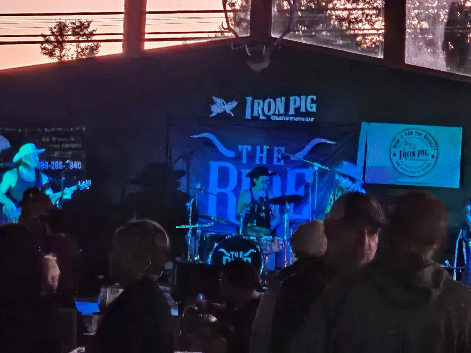 Live band The Ride performing on the main stage under the Iron Pig neon sign and buck antlers